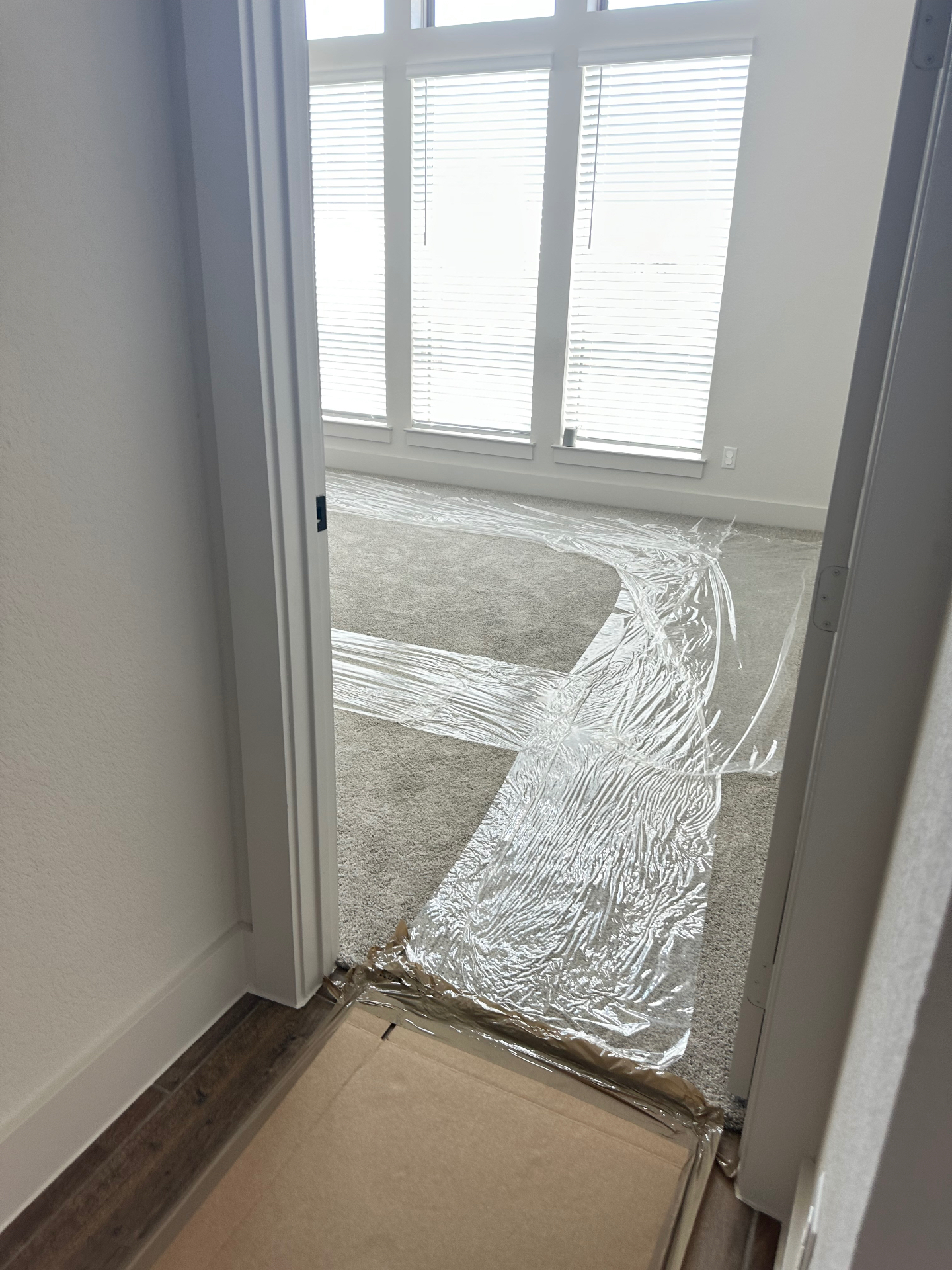 Adhesive plastic carpet film applied across bedroom carpet to protect it during a move