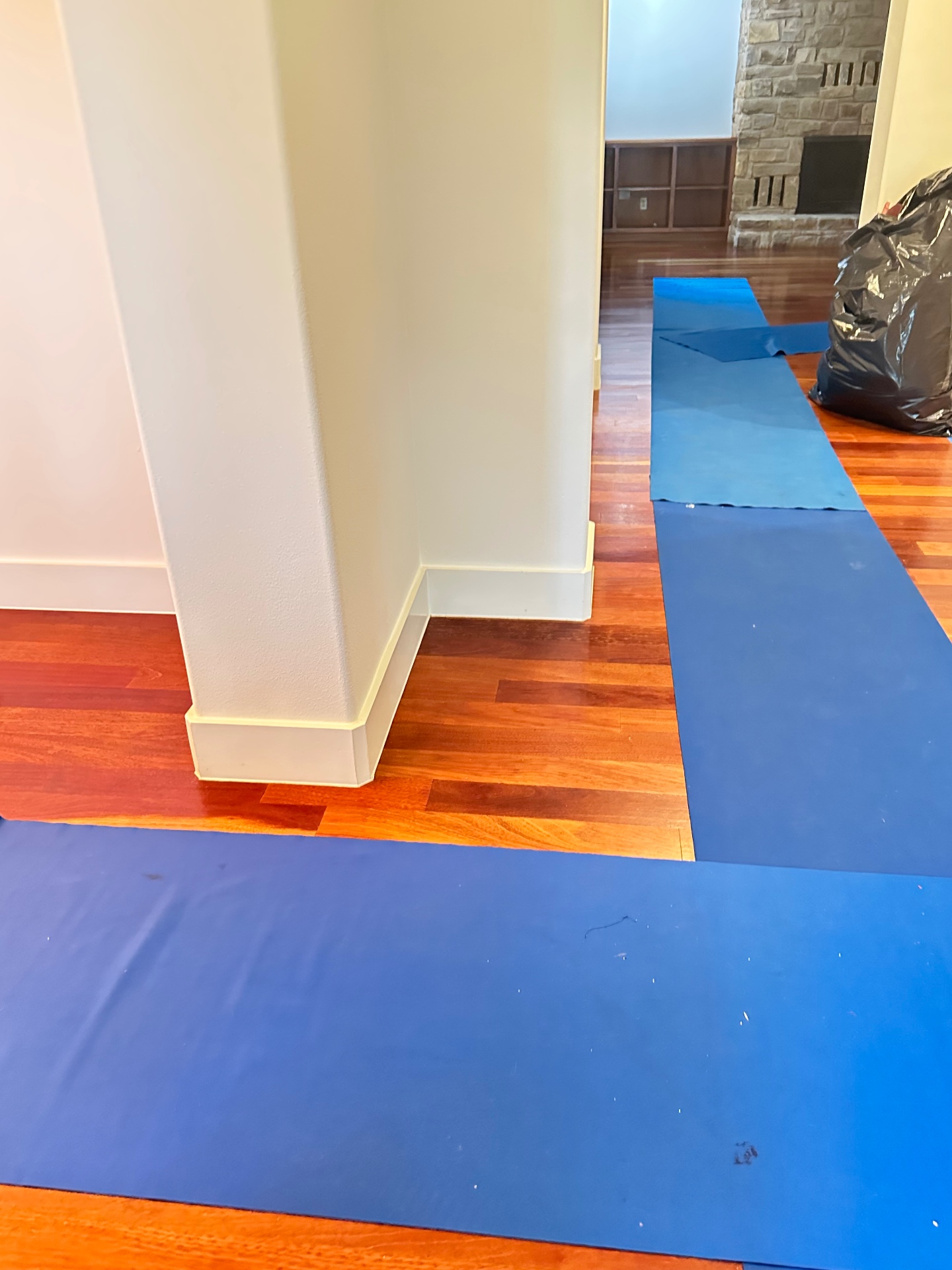 Blue floor mats layered over hardwood floors to protect them from foot traffic and dollies during a move